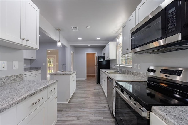 kitchen with visible vents, stainless steel appliances, light wood-type flooring, and a sink