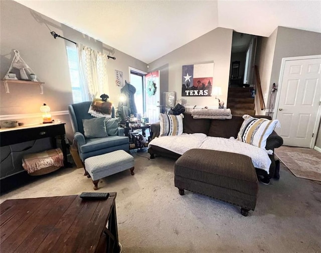 carpeted living area featuring lofted ceiling and stairs