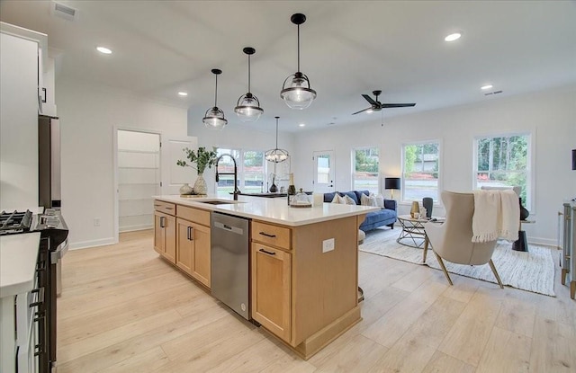 kitchen featuring dishwasher, sink, ceiling fan, an island with sink, and light brown cabinetry