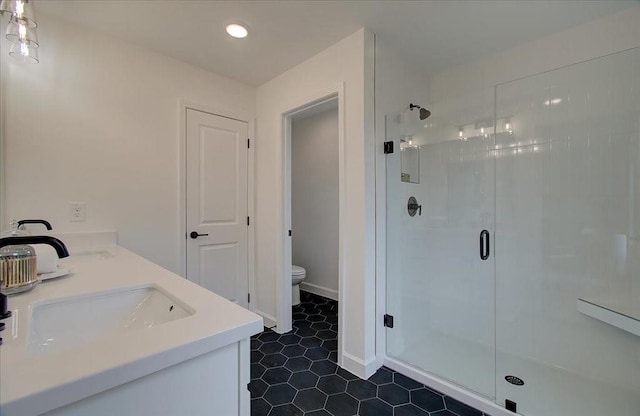 bathroom featuring tile patterned floors, a shower with door, vanity, and toilet