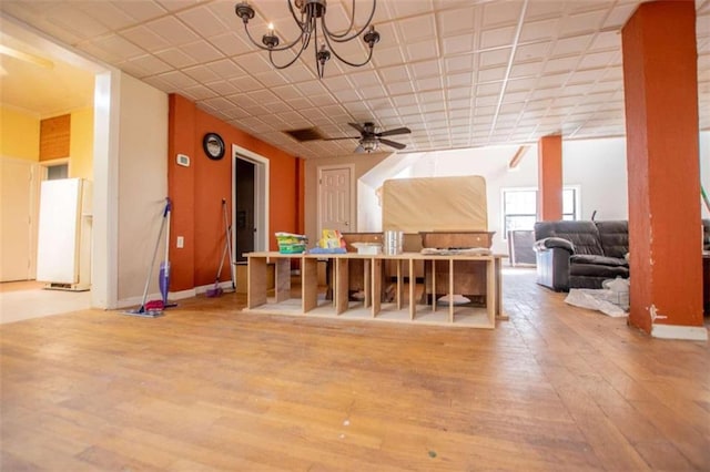 additional living space with ceiling fan with notable chandelier and light hardwood / wood-style floors