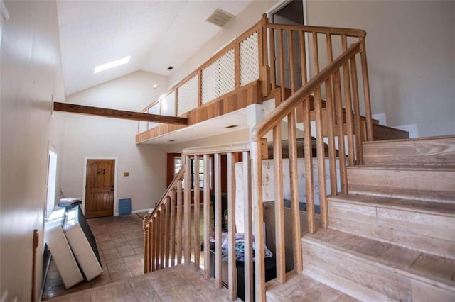 stairway featuring high vaulted ceiling