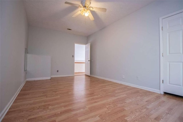 empty room with ceiling fan and light hardwood / wood-style floors