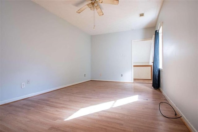 empty room featuring ceiling fan, a healthy amount of sunlight, and light hardwood / wood-style flooring