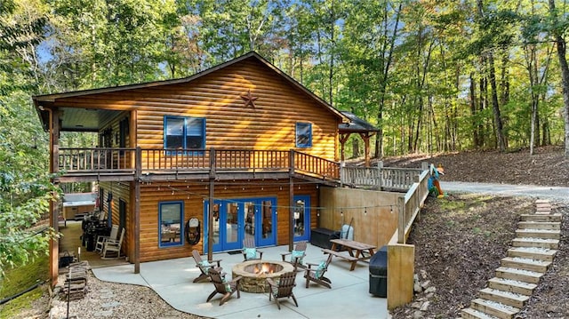 back of property with a patio, a deck, and a fire pit