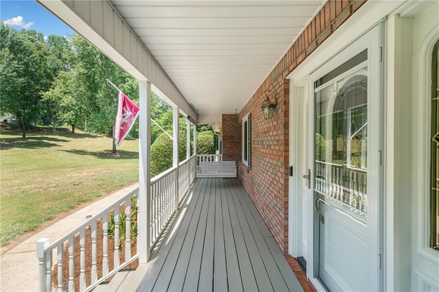 deck featuring a lawn and a porch