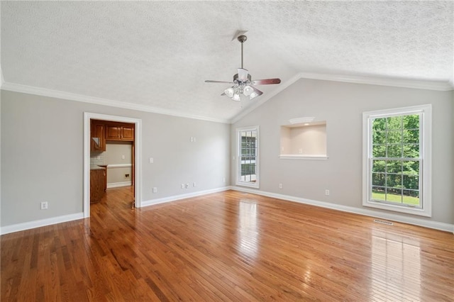 unfurnished living room with light wood-type flooring, a wealth of natural light, a textured ceiling, and lofted ceiling