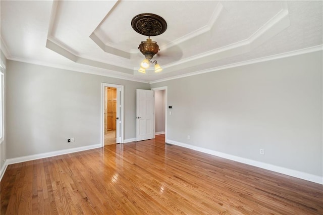 unfurnished bedroom with ornamental molding, light hardwood / wood-style flooring, ceiling fan, and a raised ceiling