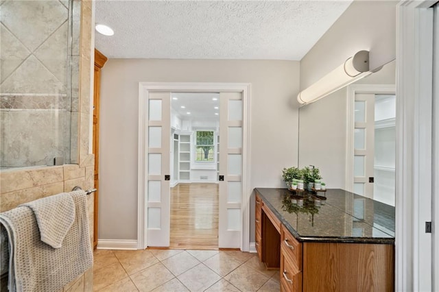 bathroom featuring tile patterned flooring and a textured ceiling