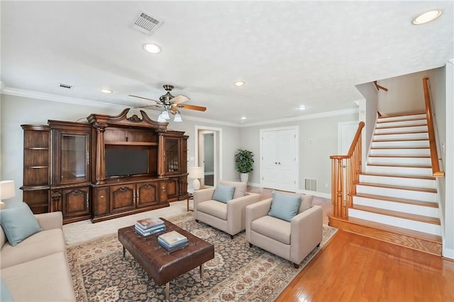 living room featuring light hardwood / wood-style floors, ceiling fan, and ornamental molding