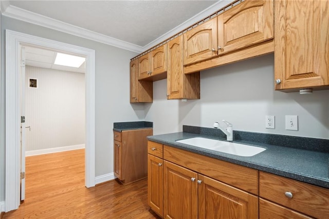 kitchen featuring sink, crown molding, and light hardwood / wood-style floors