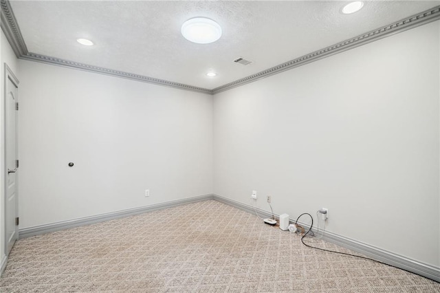 unfurnished room with a textured ceiling, ornamental molding, and carpet flooring