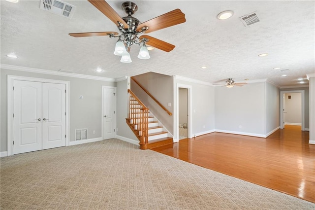 spare room featuring wood-type flooring, ceiling fan, crown molding, and a textured ceiling