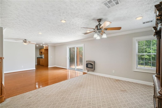 unfurnished living room featuring a textured ceiling, ceiling fan, hardwood / wood-style floors, ornamental molding, and heating unit