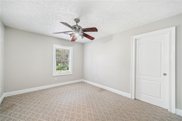 carpeted spare room featuring ceiling fan and a textured ceiling