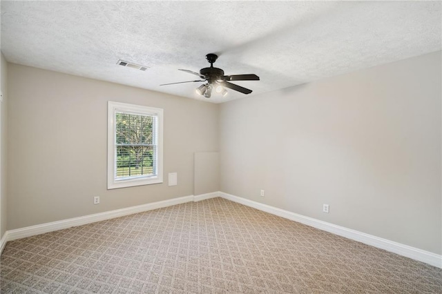 carpeted spare room with a textured ceiling and ceiling fan