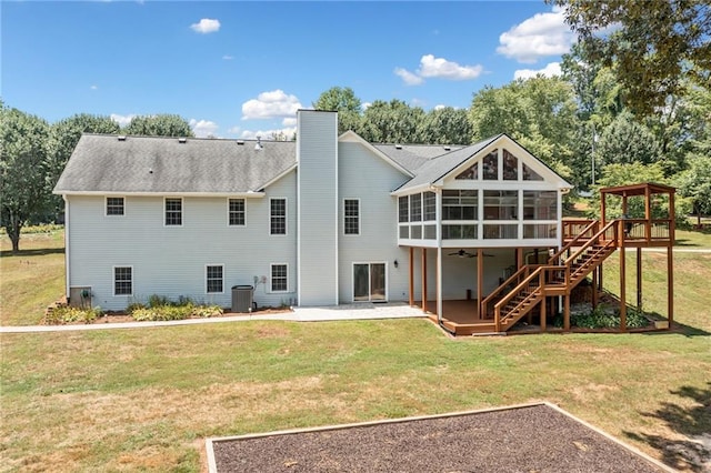 back of house featuring a patio area, a deck, a sunroom, and a lawn