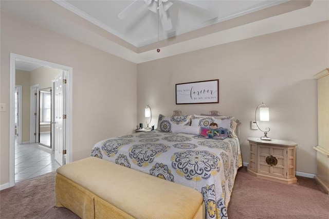 bedroom with carpet floors, a raised ceiling, baseboards, and ceiling fan
