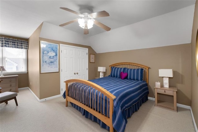 bedroom featuring carpet, a closet, baseboards, a ceiling fan, and lofted ceiling