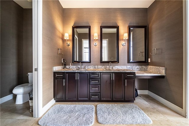 bathroom with tile flooring, dual sinks, toilet, and vanity with extensive cabinet space