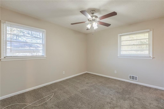 carpeted empty room with a healthy amount of sunlight and ceiling fan