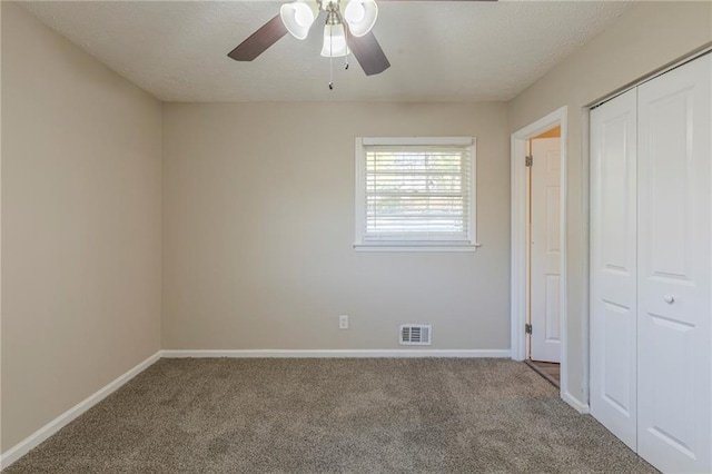 unfurnished bedroom featuring carpet, a closet, and ceiling fan