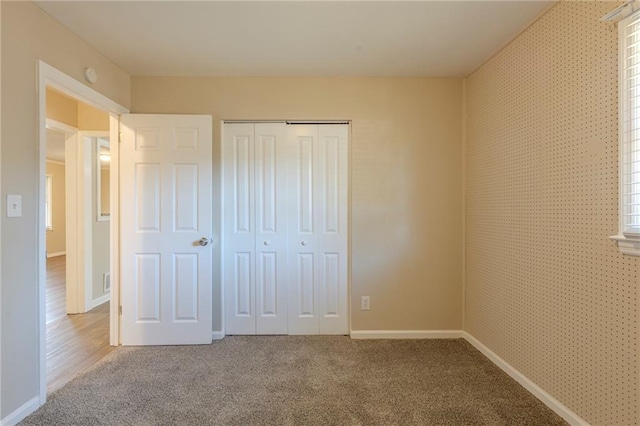 unfurnished bedroom with carpet floors and a closet