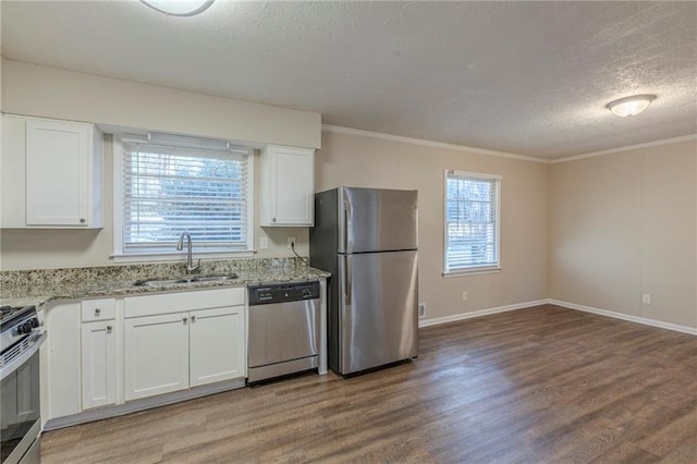 kitchen featuring sink, white cabinetry, light stone countertops, and appliances with stainless steel finishes