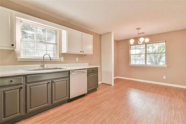 kitchen with a sink, light countertops, light wood finished floors, and dishwasher