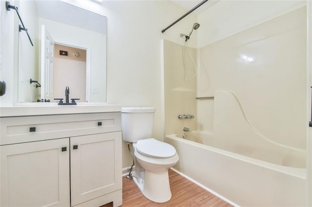 bathroom featuring vanity, bathtub / shower combination, toilet, and wood finished floors
