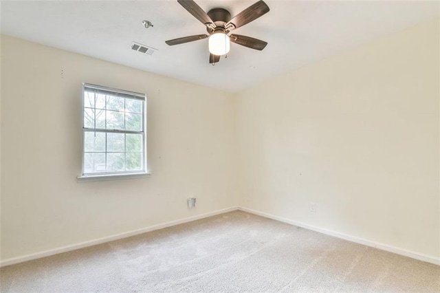 spare room with visible vents, baseboards, light colored carpet, and a ceiling fan