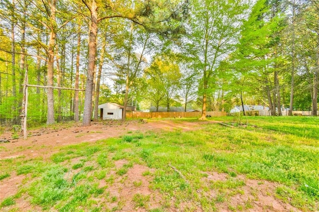 view of yard with fence and an outdoor structure