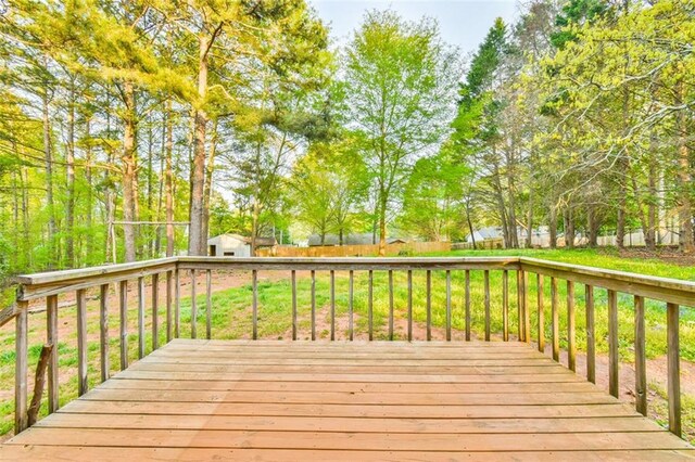 wooden terrace featuring fence and a lawn