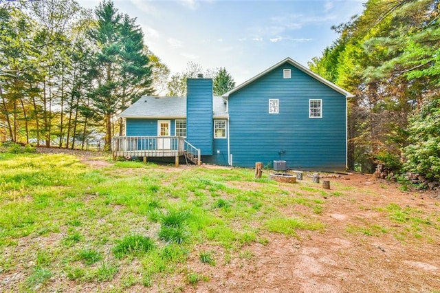 back of property featuring a wooden deck and a chimney