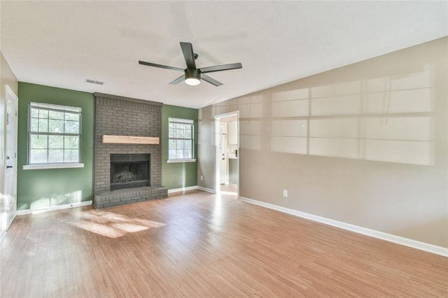 unfurnished living room with a wealth of natural light, a ceiling fan, and wood finished floors