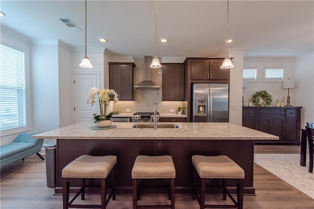 3195 Bartee Walk, Suwanee, GA 30024 - kitchen featuring stainless steel appliances, wall chimney exhaust hood, a sink, ornamental molding, and dark brown cabinetry