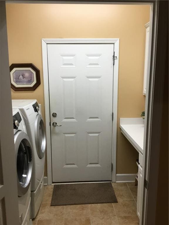 washroom with light tile patterned floors, laundry area, and washing machine and clothes dryer