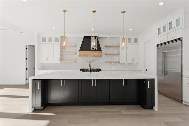 kitchen featuring stainless steel appliances, white cabinetry, and a large island with sink