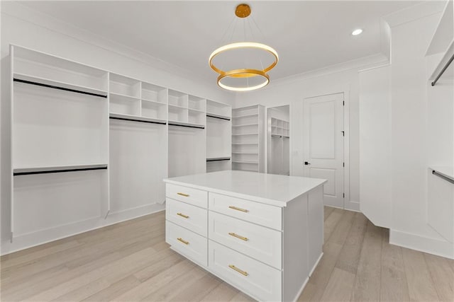 walk in closet featuring a notable chandelier and light hardwood / wood-style flooring