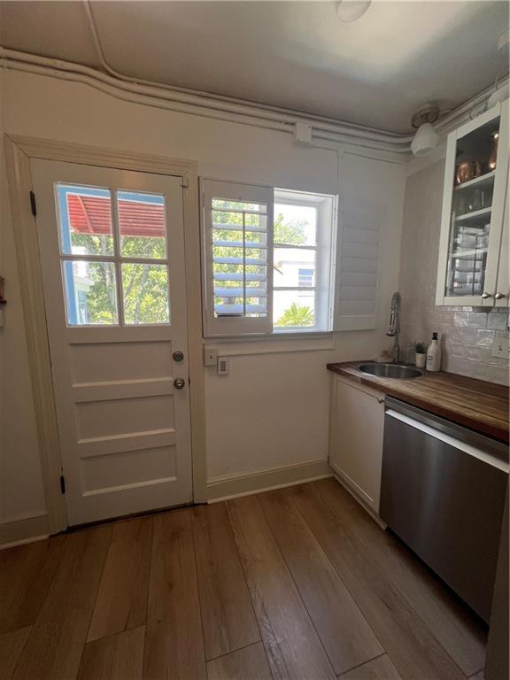 kitchen featuring light hardwood / wood-style flooring, stainless steel dishwasher, white cabinets, and sink