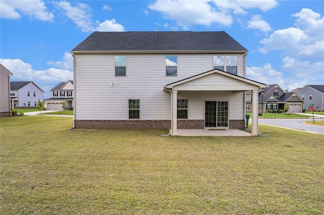 rear view of property with a yard and a patio