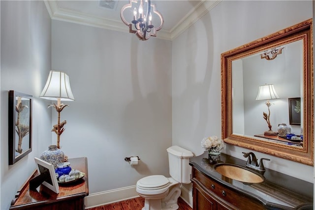 bathroom with vanity, an inviting chandelier, crown molding, toilet, and wood-type flooring