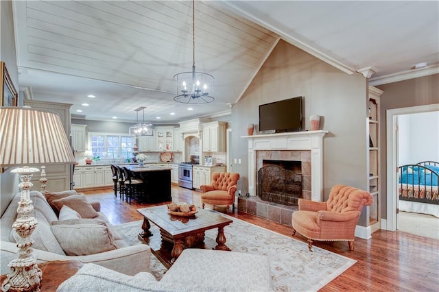 living room with a fireplace, light wood-type flooring, and ornamental molding