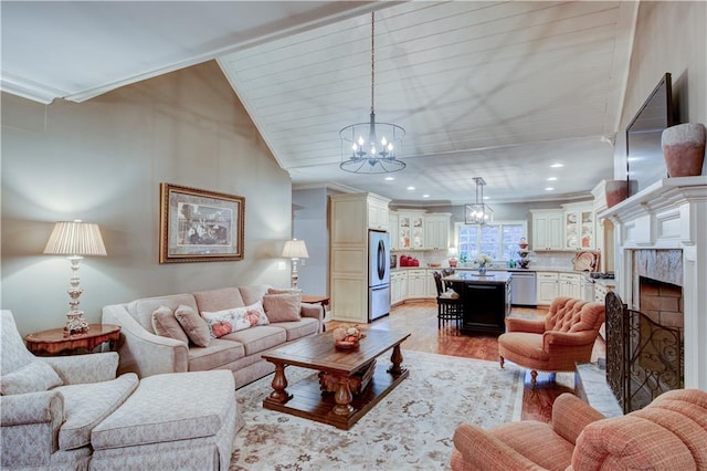 living room featuring a premium fireplace, crown molding, a chandelier, light hardwood / wood-style floors, and lofted ceiling