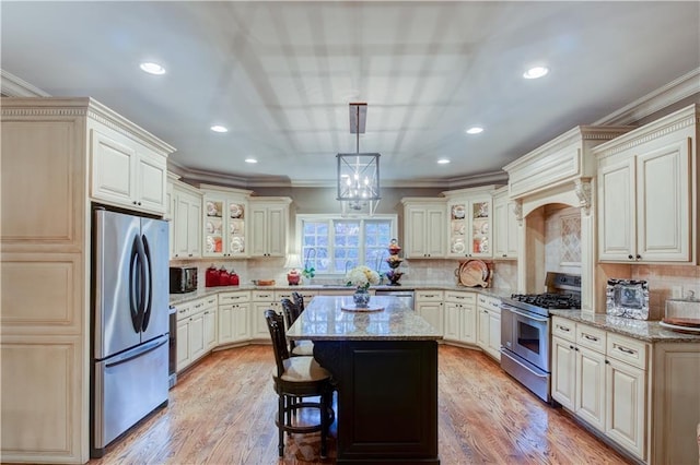 kitchen featuring light stone countertops, tasteful backsplash, stainless steel appliances, pendant lighting, and a center island