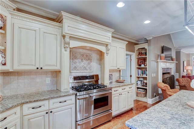 kitchen with ornamental molding, stainless steel gas stove, tasteful backsplash, and light hardwood / wood-style floors