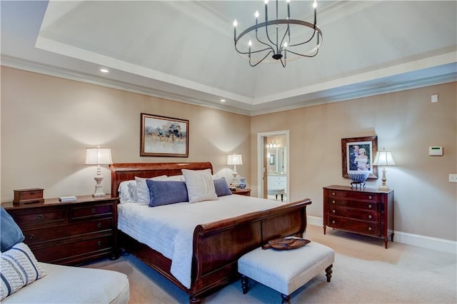 carpeted bedroom featuring a notable chandelier, crown molding, a tray ceiling, and ensuite bath