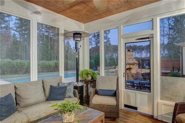 sunroom / solarium with ceiling fan and wood ceiling