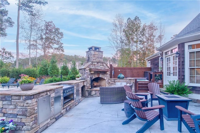 view of patio / terrace featuring an outdoor living space with a fireplace and area for grilling