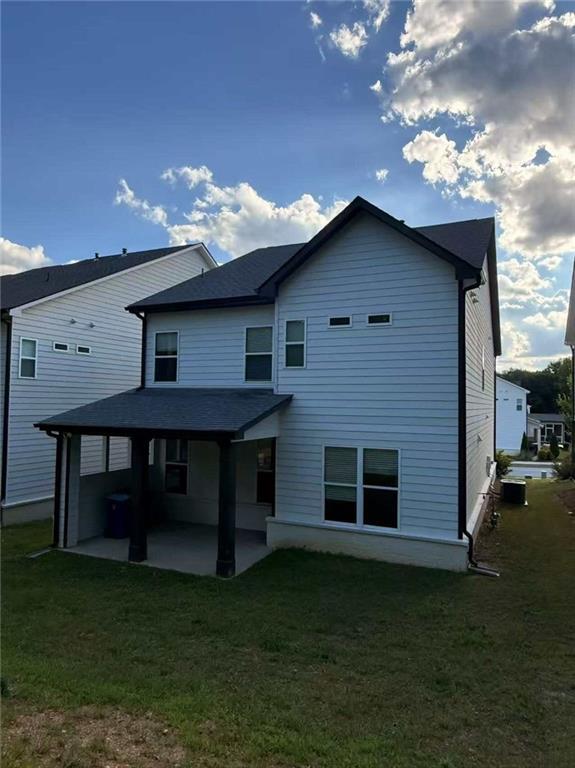 1923 Westfall Lndg, Auburn, GA 30011 - back of house featuring a patio, a lawn, and a shingled roof